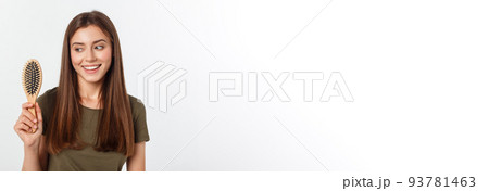 Happy young woman combing her long healthy hair on white background. Happy young woman combing her long healthy hair on white background. 93781463