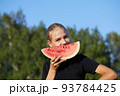 Young girl holding watermelon on nature background 93784425