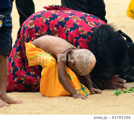 Hindu devotees in Katagama Dewalaya, Mother, and her son kneel down on the sand and worships the God of Kataragama. Hindu devotees in Katagama Dewalaya, Mother, and her son kneel down on the sand and worships the God of Kataragama. 93785396