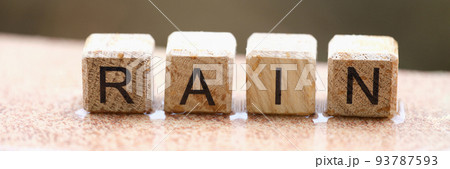 Wooden cubes with words rain lying on wet windowsill closeup Wooden cubes with words rain lying on wet windowsill closeup 93787593