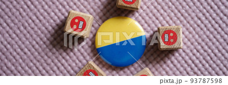 Badge with flag of Ukraine lying among evil emoticons closeup 93787598