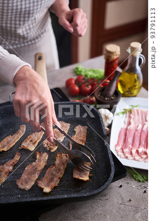 Bacon slices fying on grill frying pan Skillet at domestic kitchen 93791113