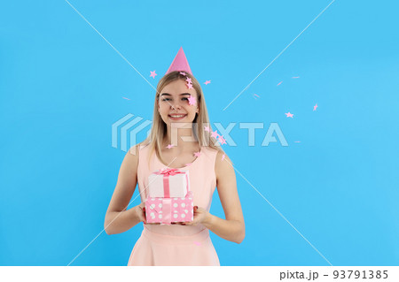 Concept of Happy Birthday, young woman on blue background Concept of Happy Birthday, young woman on blue background 93791385