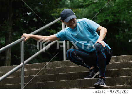 階段を下るランナーの膝の痛みイメージ 93792700