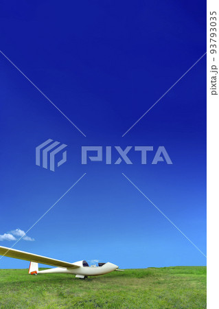 青空を背景に緑の高原に駐機する白いグライダー 93793035