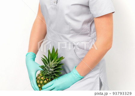 Female doctor beautician with pineapple. Concept of epilation or depilation and intimate hygiene 93793329
