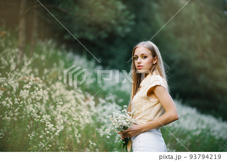 Portrait of a sweet gentle girl in a field of white flowers Portrait of a sweet gentle girl in a field of white flowers 93794219