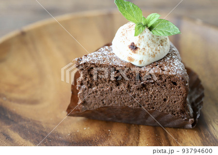 生クリームにミントを飾ったカットしたガトーショコラ 93794600