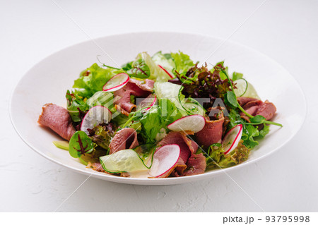 Roast beef salad with green mix on plate 93795998
