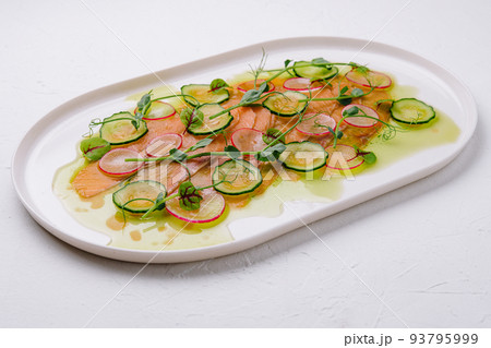 Buffet serving of pickled salmon slices with radish, cucumber 93795999