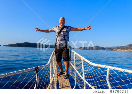 Man standing on the white bow of yacht with a magnificent view of the Mediterranean sea in Turkey 93796212