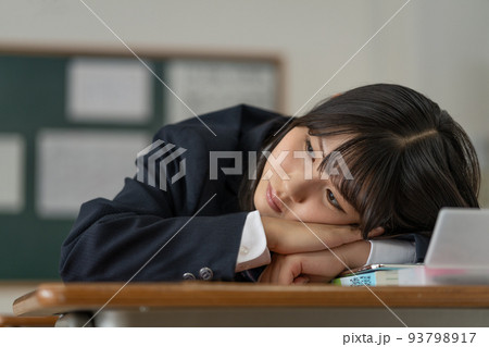 学校の休み時間に机に伏せて悩む女子高生 93798917