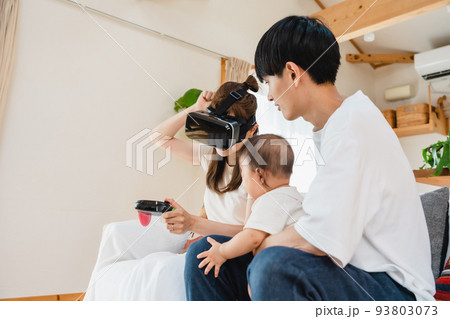 リビングでVRゴーグルをつける家族 93803073