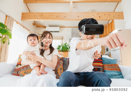 リビングでVRゴーグルをつける家族 93803092