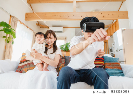 リビングでVRゴーグルをつける家族 93803093