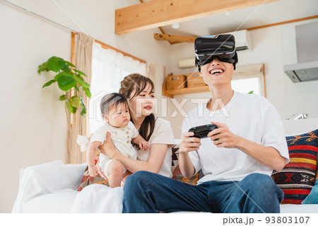 リビングでVRゴーグルをつける家族 リビングでVRゴーグルをつける家族 93803107