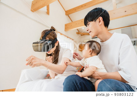 リビングでVRゴーグルをつける家族 リビングでVRゴーグルをつける家族 93803122