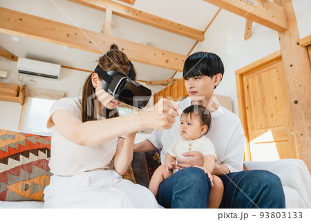 リビングでVRゴーグルをつける家族 リビングでVRゴーグルをつける家族 93803133