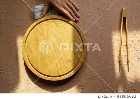 Empty wooden dishes, kitchen utensils on a brown background. Eco-friendly tableware. Top view. Empty wooden dishes, kitchen utensils on a brown background. Eco-friendly tableware. Top view. 93806632