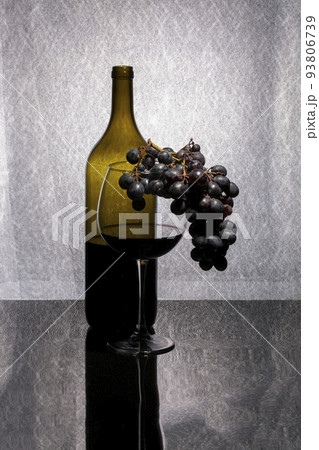 Still life with red wine in a glass and bottle and a bunch of ripe grapes 93806739
