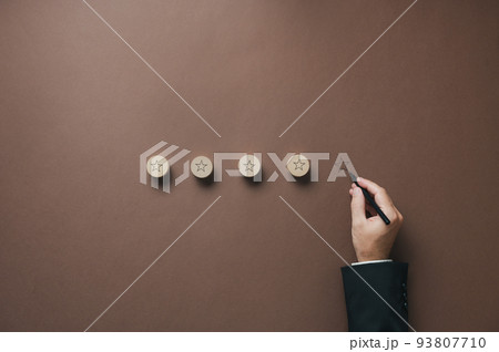Four stars drawn on wooden cut circles with a hand of a businessman drawing the fifth one Four stars drawn on wooden cut circles with a hand of a businessman drawing the fifth one 93807710