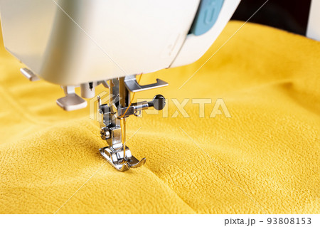 Modern sewing machine and yellow fabric. Sewing process, handmade, hobby, DIY, business, repair 93808153