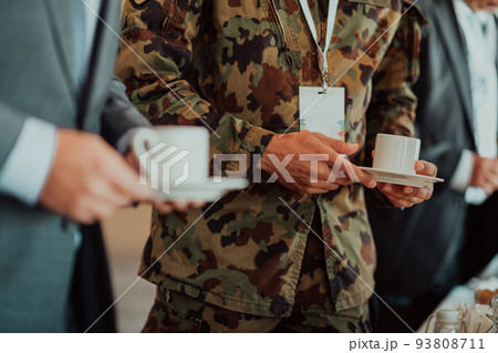 Close-up photo of soldier serving themselves in a modern hotel during a dinner party. Selective focus Close-up photo of soldier serving themselves in a modern hotel during a dinner party. Selective focus 93808711