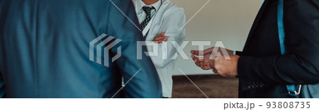 The conversation of businessmen standing in the great corridor of a modern corporation 93808735