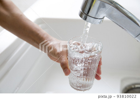 キッチンでグラスに水を満たす主婦の手元 キッチンでグラスに水を満たす主婦の手元 93810022