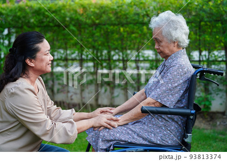 Caregiver help Asian elderly woman disability patient sitting on wheelchair in park, medical concept. Caregiver help Asian elderly woman disability patient sitting on wheelchair in park, medical concept. 93813374