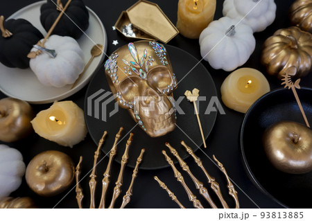 Creative photo with a golden skull and a luxurious table setting  93813885