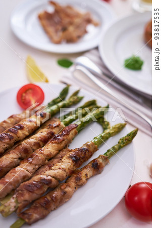 Tasty breakfast - Asparagus wrapped with bacon and spices on a plate 93817535