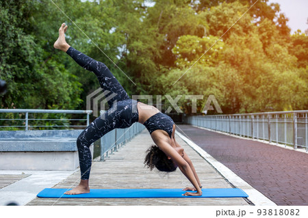 Woman doing yoga at outdoors garden. Woman is stretching in yoga at Garden. work out time	 Woman doing yoga at outdoors garden. Woman is stretching in yoga at Garden. work out time	 93818082