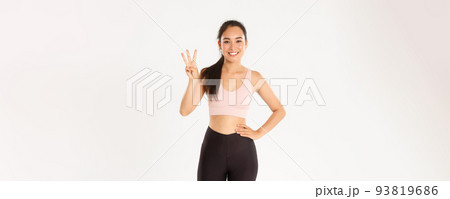 Sport, wellbeing and active lifestyle concept. Smiling sportswoman, asian fitness girl showing three useful exercises for losing weight or gaining muscles, standing white background in activewear Sport, wellbeing and active lifestyle concept. Smiling sportswoman, asian fitness girl showing three useful exercises for losing weight or gaining muscles, standing white background in activewear 93819686