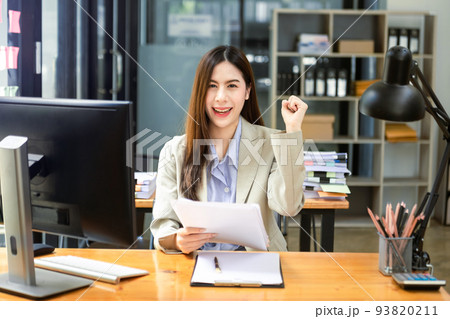 Asian business woman are delighted and happy with the work they do on their tablet, laptop and taking notes at the office. 93820211