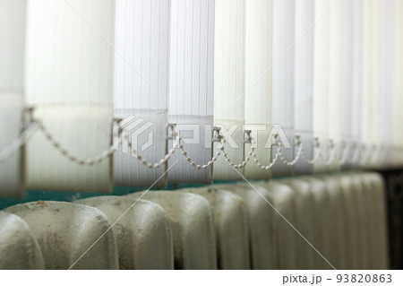 White blinds on the window above the radiator 93820863