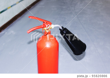 Red fire extinguisher in the room closeup 93820866