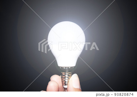 Glowing light bulb in hand in the dark Glowing light bulb in hand in the dark 93820874