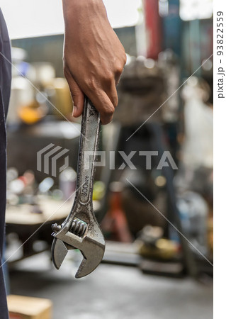 Wrench in Hand of car mechanic. Hand holding a metal Wrench	 93822559