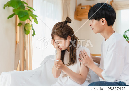 妊娠検査薬を確認する夫婦 93827495