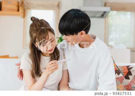 妊娠検査薬を確認する夫婦 妊娠検査薬を確認する夫婦 93827531
