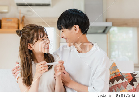 妊娠検査薬を確認する夫婦 93827542