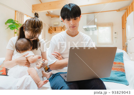 リビングでノートパソコンを開く男性 リビングでノートパソコンを開く男性 93829043