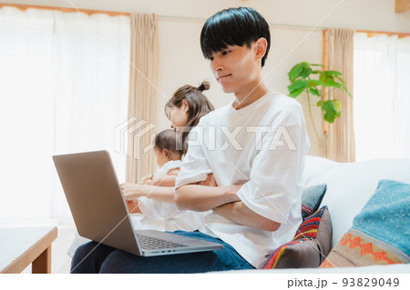 リビングでノートパソコンを開く男性 リビングでノートパソコンを開く男性 93829049