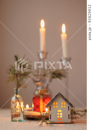 Christmas tree and a candlestick in the form of a house, a cozy miniature layout of the house. decorations for Christmas with candles, 93829912
