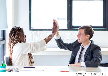 Coworkers cooperating and working together at office meeting Coworkers cooperating and working together at office meeting 93830316
