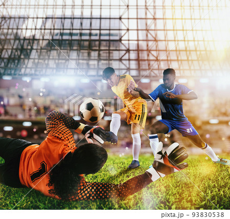 Goalkeeper catches the ball in the stadium during a football game. 93830538