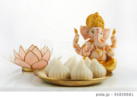 Idol of lord Ganesha with Modak Sweet Dish and flower. Ganesh chaturthi 93830681