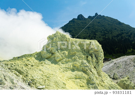 bright smoking fumarole with sulfur deposits against the background of the Mendeleev volcano peak on the island of Kunashir 93831181