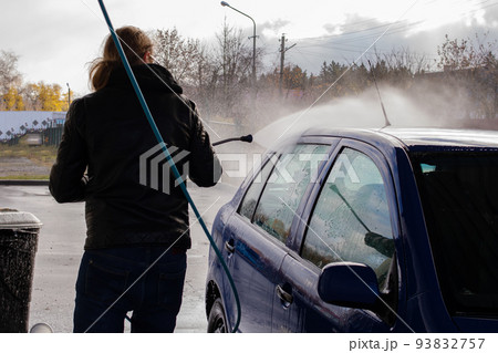 A man washing a car at a car wash A man washing a car at a car wash 93832757